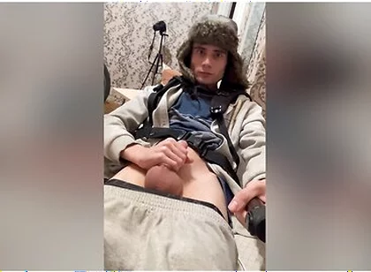 A Guy In A Winter Hat With Earflaps And A Blue Jacket, Masturbates His Penis And Cums With Hot Sperm